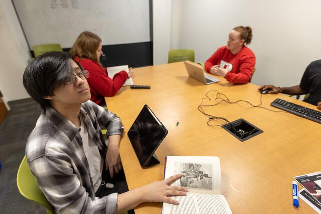 Four students in one of the study rooms at the Robeson library