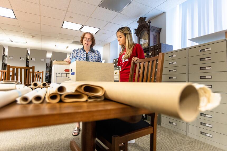 Librarian and student search archives in Special Collections and University Archives