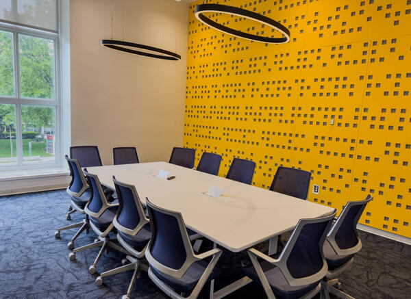 Large conference table with 12 chairs and yellow wall