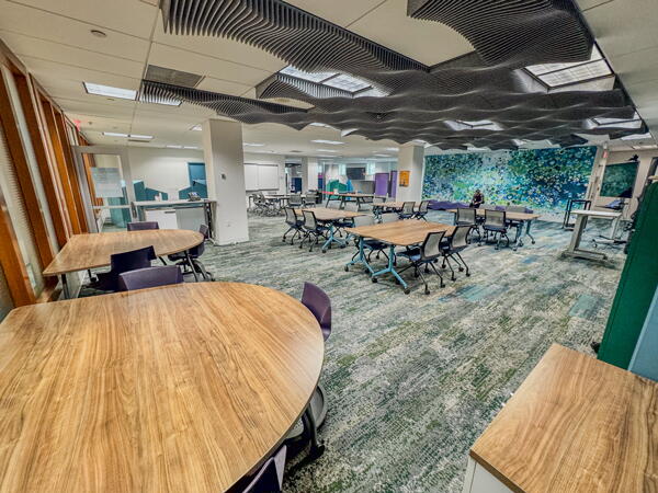 Large classroom-style space with multiple group tables and chairs
