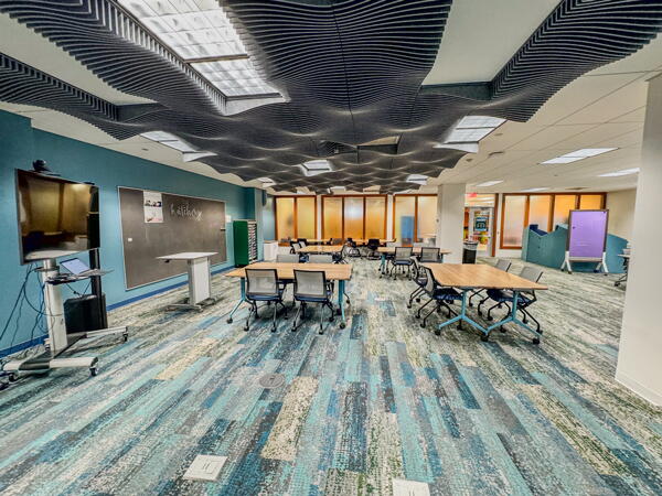 Large classroom-style space with multiple group tables and chairs