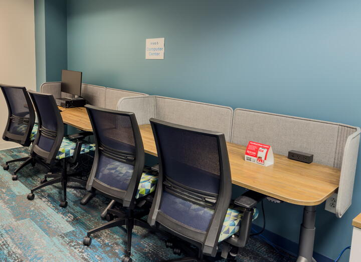 Four chairs at one long computer station desk