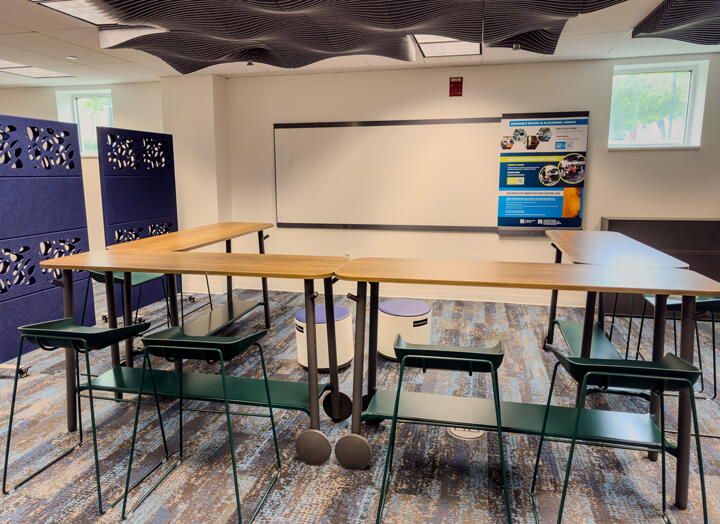 U-shaped high table and stools facing large whiteboard