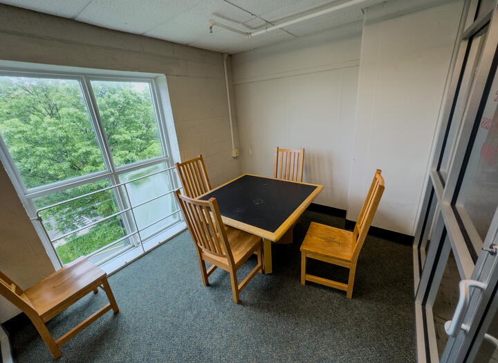 Group study room with square table, four chairs and a large window