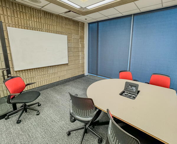 Interior of study room with table, chairs, and wall-mounted whiteboard