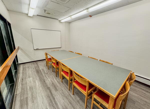 Group study room with table, chairs, and wall-mounted whiteboard