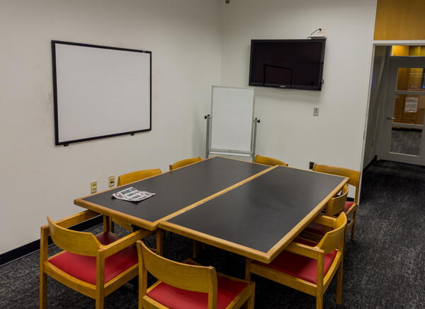 Group study room with table, chairs, and a wall-mounted whiteboard