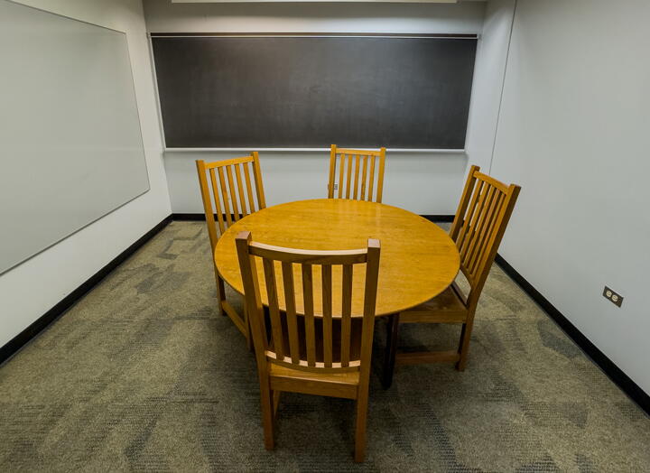 Interior of group study room with table, chairs, and wall-mounted whiteboard and chalkboard
