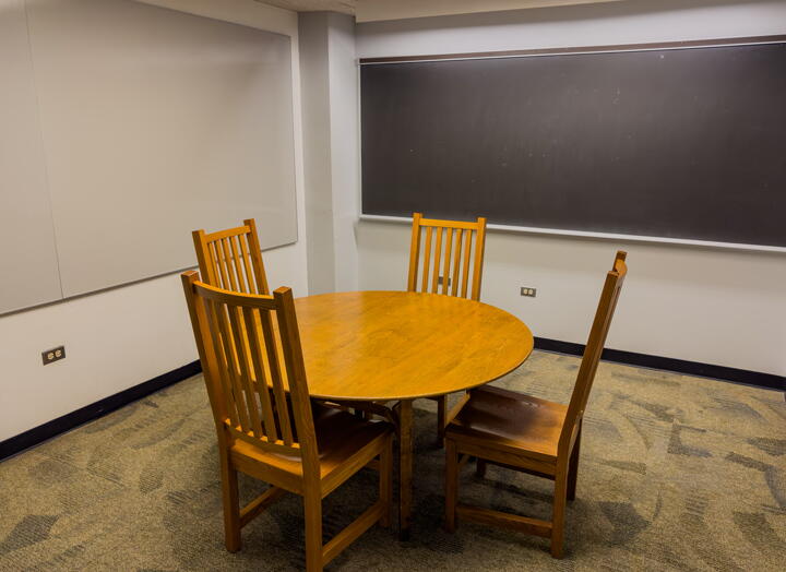 Interior of group study room with table, chairs, and wall-mounted whiteboard and chalkboard