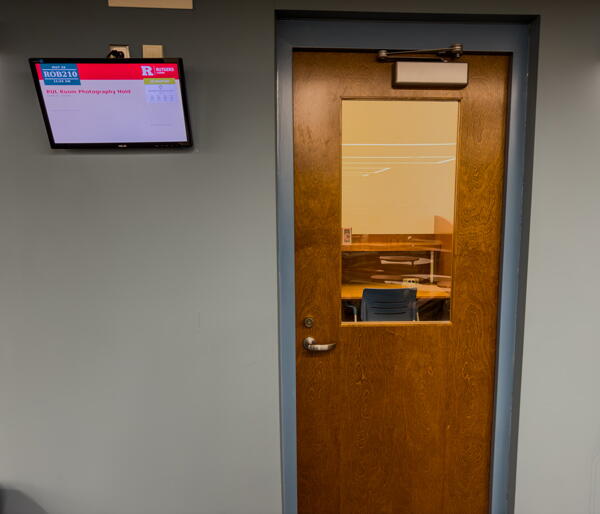 Closed entry door to Study Room 210 with wall-mounted digital screen