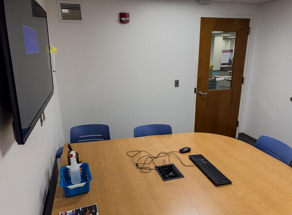 Closeup of group table with keyboard, mouse, and cables for use with wall-mounted display and whiteboard accessories