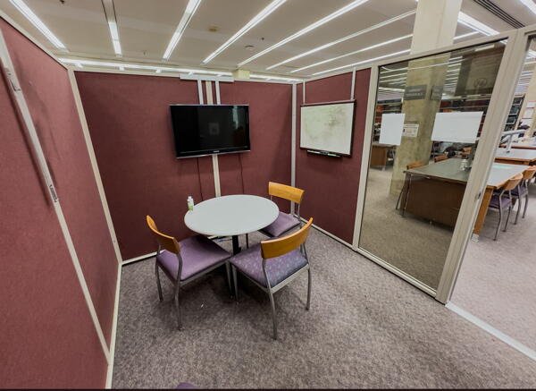 Group study room with round table and four chairs, and a wall-mounted display and whiteboard