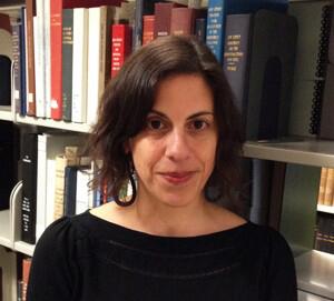 Image of Christine Lutz standing in front of book shelves wearing a black top